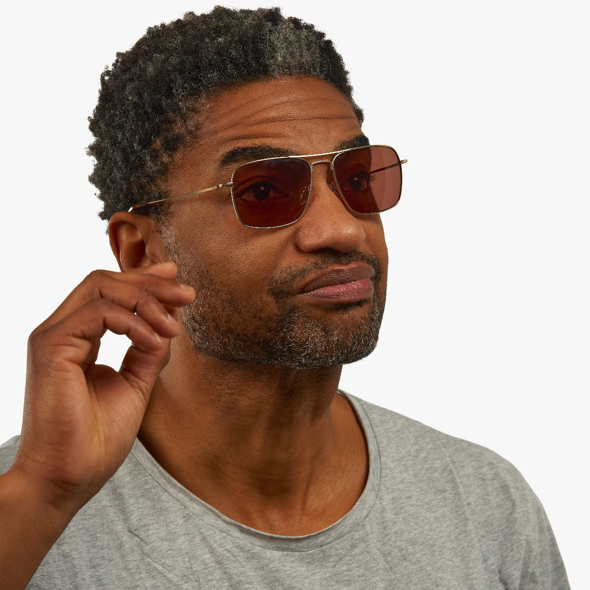 Person wearing Lidköping Gold sunglasses with dark lenses