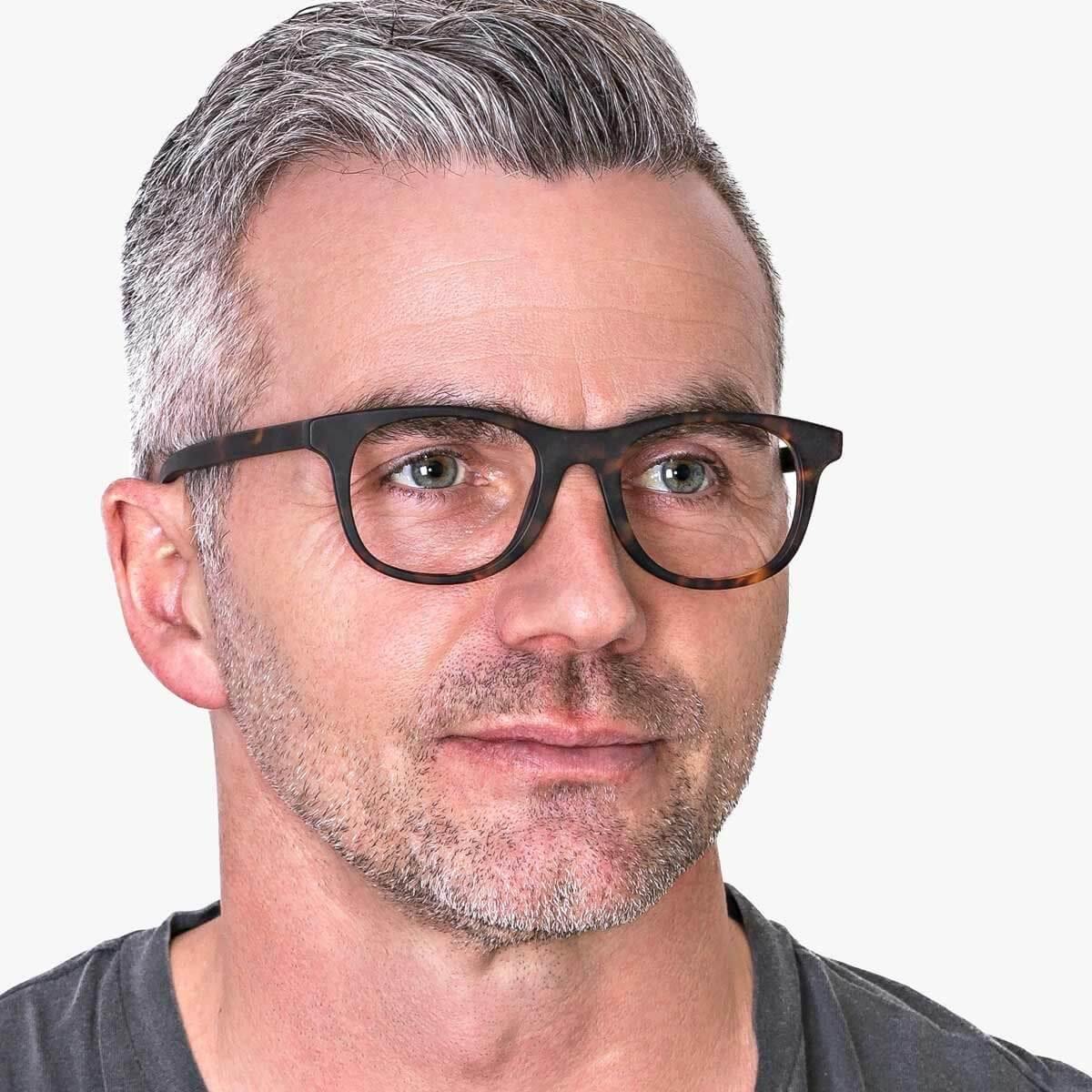 Person wearing dark turtle pattern glasses