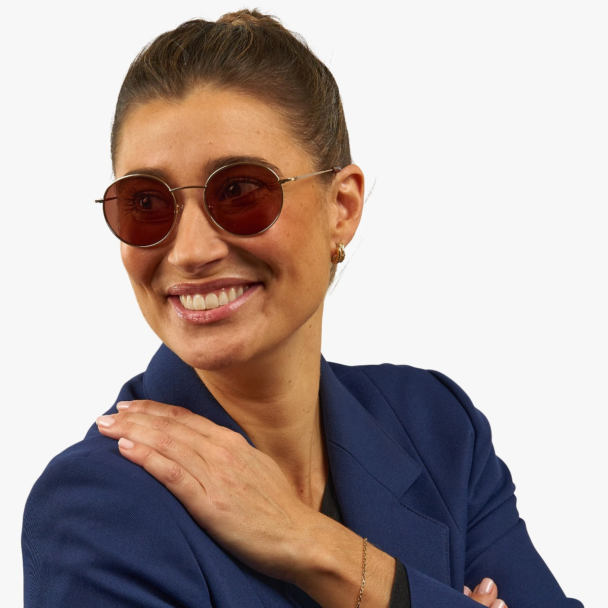 Person wearing round brown sunglasses with gold frames